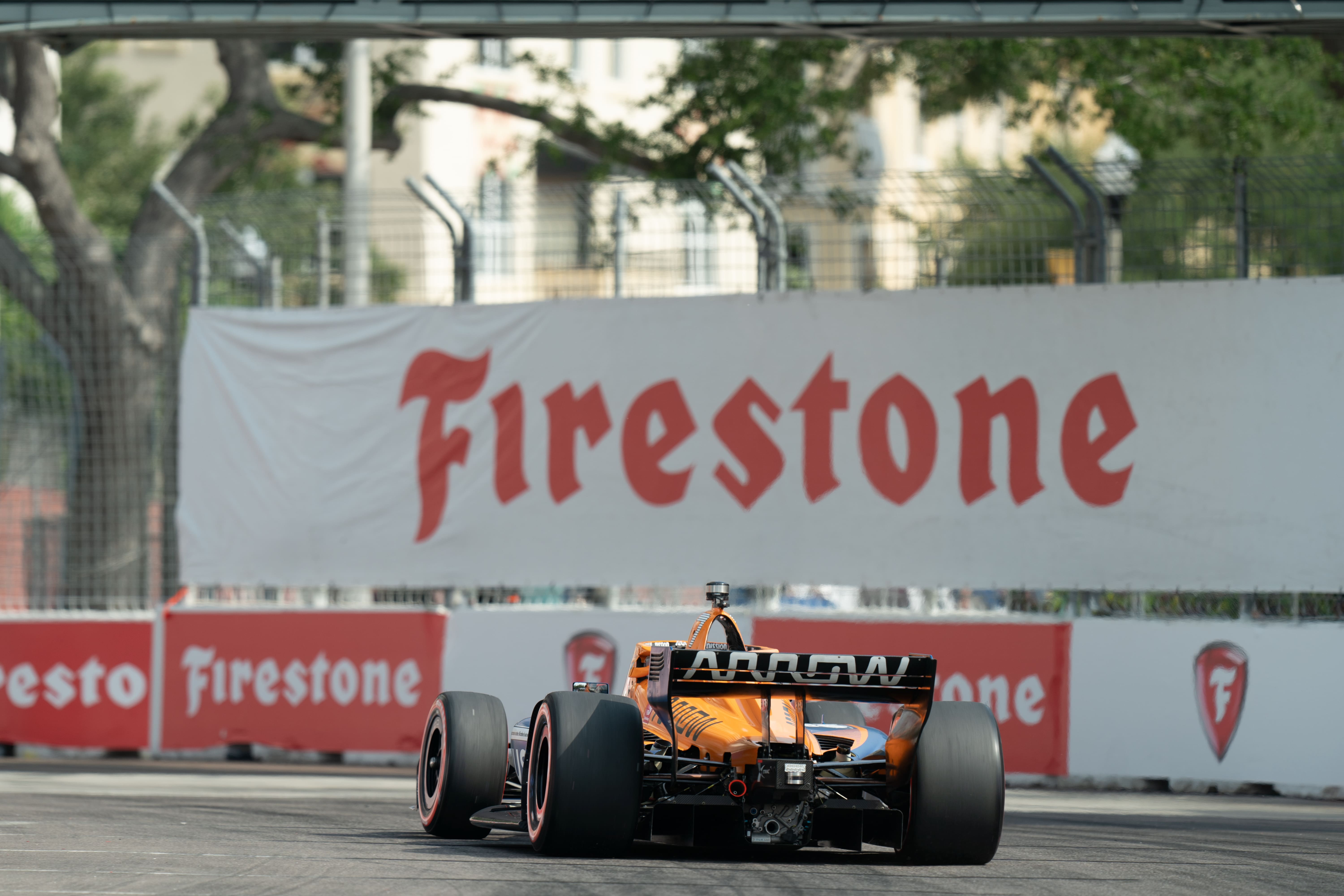 Sebastien Bourdais crossing the finish line with sponsor signage in the background